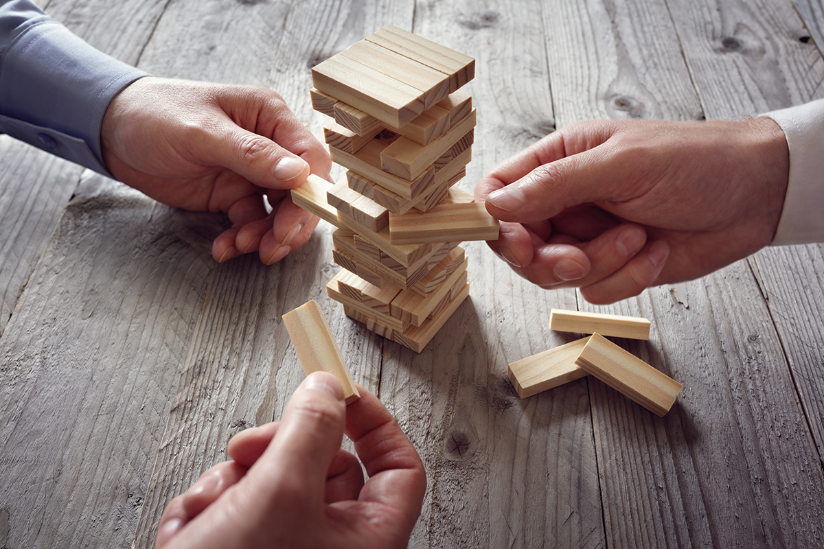 closeup of hands playing a game of jenga