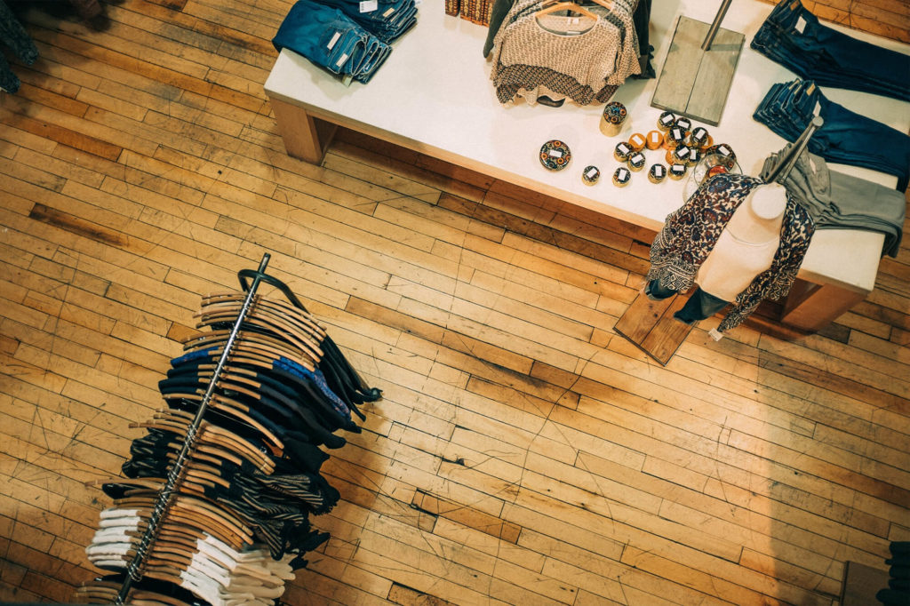 top down view of a clothing store with apparel hanging and folded on a table